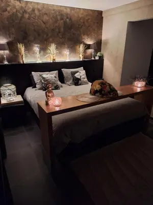 a bedroom with a large bed with a wooden headboard at Maison Beau in Zonhoven