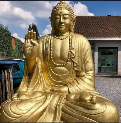 a gold statue of a buddha sitting in front of a house at Maison Beau in Zonhoven