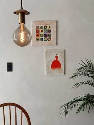 two paintings of a dress on a wall with a lamp at Residentie Papillon in Hasselt