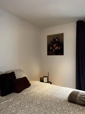 a bedroom with a bed and a painting on the wall at Residentie Papillon in Hasselt