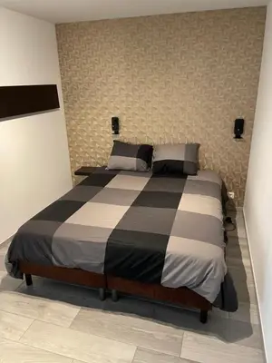 a bedroom with a large bed with black and white sheets at Residence pascalino in Ans