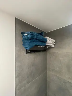 a pile of towels on a towel rack in a bathroom at Residence pascalino in Ans