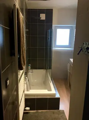 a bathroom with a bath tub and a window at La Vie Hors Château in Liège