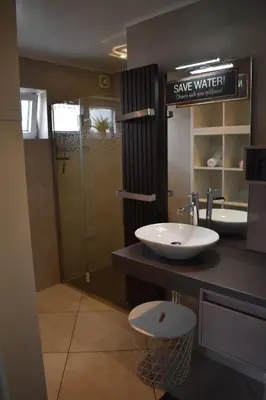a bathroom with a sink and a walk in shower at Luxury House in Remersdaal