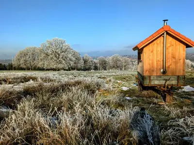a wooden outhouse sitting in a field with snow at La Petite Maison dans la Prairie in Pepinster