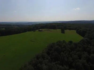 an aerial view of a green field with a house at La Petite Maison dans la Prairie in Pepinster
