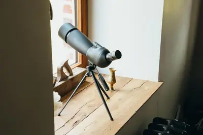 a telescope sitting on a table next to a window at La Petite Maison dans la Prairie in Pepinster