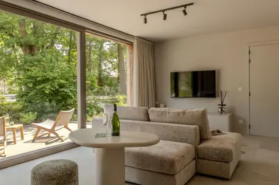 a living room with a couch and a table at Suite - 2 personen - Woodz Lodges in Heusden - Zolder