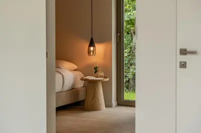 a bedroom with a bed and a table next to a window at Suite - 2 personen - Woodz Lodges in Heusden - Zolder