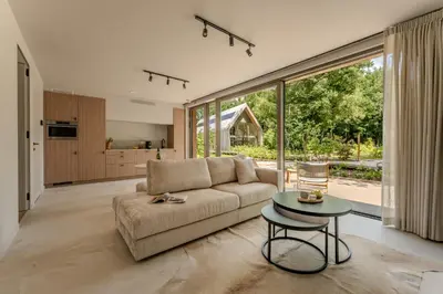 a living room with a couch and a table at Suite - 2 personen - Woodz Lodges in Heusden - Zolder