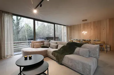 a living room with a couch and a table at Lodge met Jacuzzi - 8 personen - Woodz Lodges in Heusden - Zolder