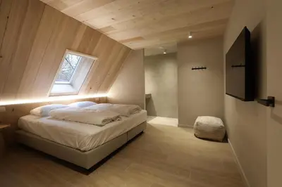 a bedroom with a bed with a window and a television at Lodge met Jacuzzi - 8 personen - Woodz Lodges in Heusden - Zolder