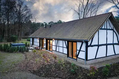 a small house with a black and white roof at Villa Lodge met Jacuzzi - 8 personen - Woodz Lodges in Heusden - Zolder