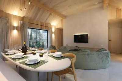 a living room with a table and a couch at Villa Lodge met Jacuzzi - 8 personen - Woodz Lodges in Heusden - Zolder