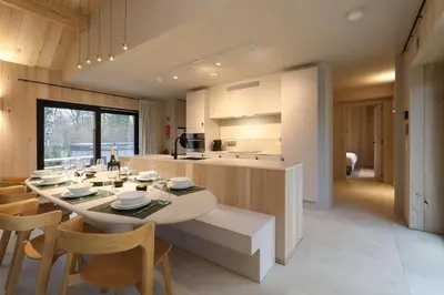 a kitchen and dining room with a table and chairs at Villa Lodge met Jacuzzi - 8 personen - Woodz Lodges in Heusden - Zolder