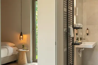 a bathroom with a bed and a sink and a mirror at Suite Toegankelijk | 2 personen in Heusden - Zolder
