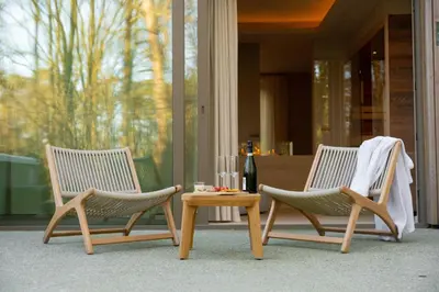 two chairs and a coffee table on a porch at Wellness Suite - 2 personen - Woodz Lodges in Heusden - Zolder