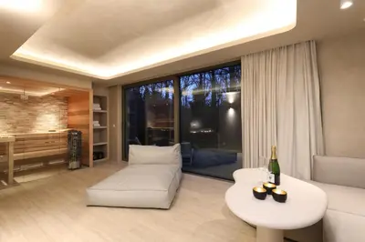 a living room with a white couch and a table at Wellness Suite - 2 personen - Woodz Lodges in Heusden - Zolder