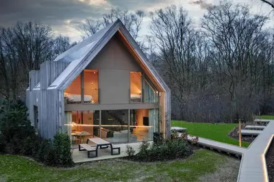 a small house with a large window on a lawn at Lodge - 8 personen - Woodz Lodges in Heusden - Zolder