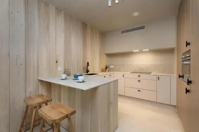 a kitchen with a counter and stools in it at Lodge - 8 personen - Woodz Lodges in Heusden - Zolder
