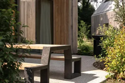a wooden bench sitting in front of a building at Lodge - 8 personen - Woodz Lodges in Heusden - Zolder