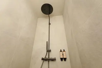 a shower with two shampoo bottles on the wall at Lodge - 6 personen - Woodz Lodges in Heusden - Zolder