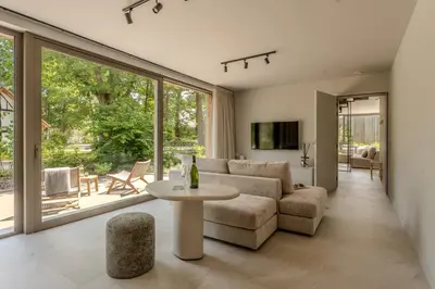 a living room with a couch and a table at Groepslodge - 10 personen - Woodz Lodges in Heusden - Zolder