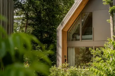 a house with a window on the side of it at Groepslodge - 10 personen - Woodz Lodges in Heusden - Zolder