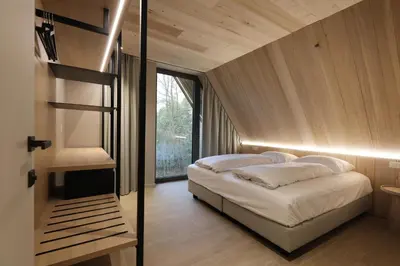 a bedroom with a bed and a large window at Lodge met Jacuzzi - 6 personen - Woodz Lodges in Heusden - Zolder