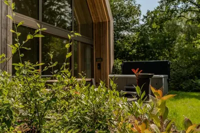 a screened in porch of a house with plants at Lodge met Jacuzzi - 6 personen - Woodz Lodges in Heusden - Zolder