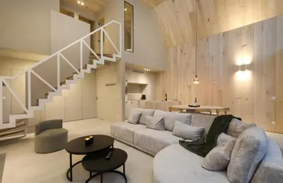 a living room with a couch and a staircase at Lodge met Jacuzzi - 6 personen - Woodz Lodges in Heusden - Zolder