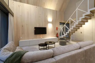 a living room with a couch and a staircase at Lodge met Jacuzzi - 6 personen - Woodz Lodges in Heusden - Zolder