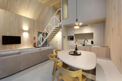 a kitchen and living room with a table and a couch at Lodge met Jacuzzi - 6 personen - Woodz Lodges in Heusden - Zolder