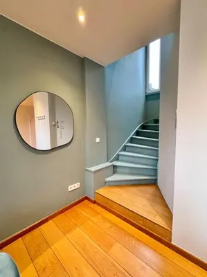 a hallway with a circular mirror and a staircase at Urbanchic Duplex Adalbert 2A in Liège