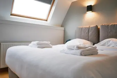 a bedroom with a white bed with towels on it at Urbanchic Duplex Adalbert 2A in Liège