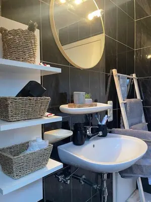 a bathroom with a sink and a mirror and baskets at Casa Kanella Vakantiewoning in Maasmechelen