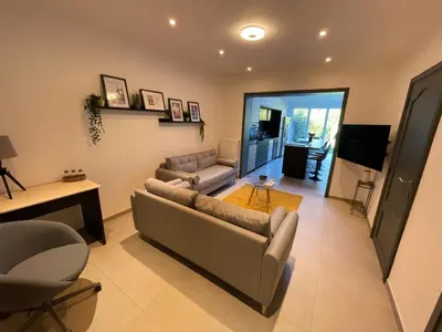 a living room with two couches and a television at Au 11801 Bel appartement moderne in Loncin