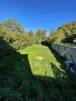 a large grassy yard with a fence and trees at Au 11801 Bel appartement moderne in Loncin