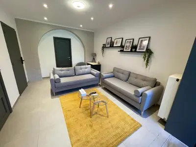 a living room with two couches and a table at Au 11801 Bel appartement moderne in Loncin