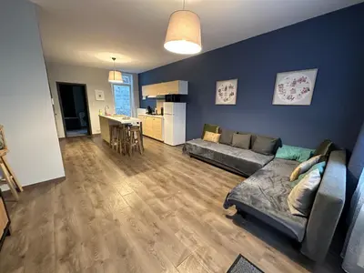 a living room with a couch and a kitchen at Au 167 Maison de Village in Seraing