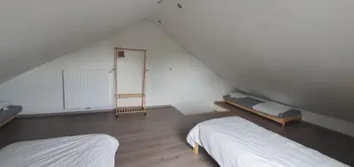 a attic bedroom with two beds and a mirror at Au 167 Maison de Village in Seraing