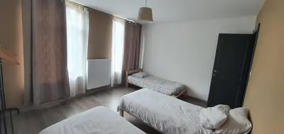 a room with a bed and a chair and a window at Au 167 Maison de Village in Seraing