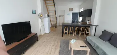 a living room with a flat screen tv and a couch at Au 169 La maison du coin in Flémalle-Grande
