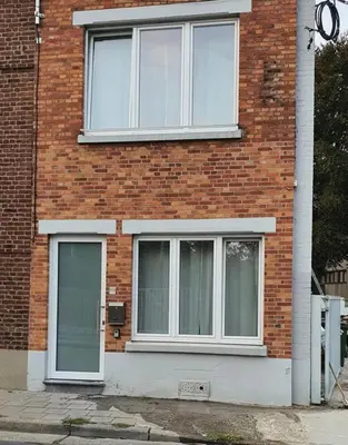 a brick building with three windows on it at Au 169 La maison du coin in Flémalle-Grande