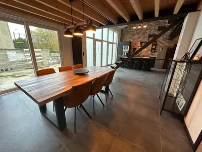 a dining room with a wooden table and chairs at Au 171 Le loft avec un sauna in Flémalle-Grande