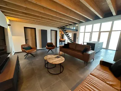 a living room with a couch and a table at Au 171 Le loft avec un sauna in Flémalle-Grande