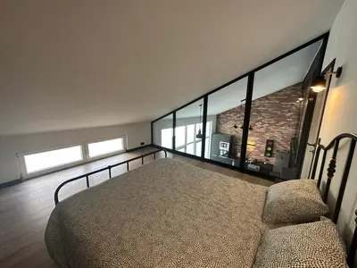 a bedroom with a bed and a brick wall at Au 171 Le loft avec un sauna in Flémalle-Grande