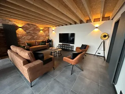 a living room with couches and a flat screen tv at Au 171 Le loft avec un sauna in Flémalle-Grande