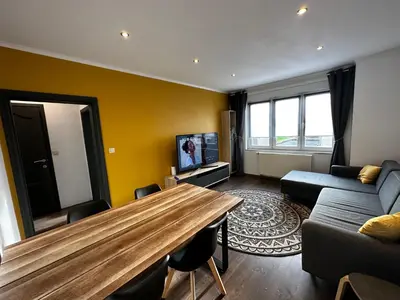 a living room with a wooden table and a couch at Au 11811 Bel appartement cosy in Loncin