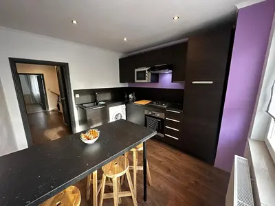 a kitchen with a black counter top and purple at Au 11811 Bel appartement cosy in Loncin